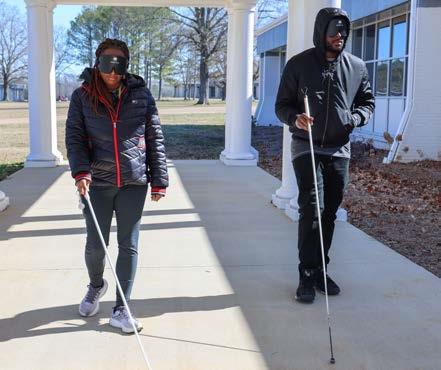 Roana Norton and Tyree James navigate campus while wearing learning shades. 